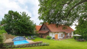 A house with a swimming pool, a well-maintained lawn, and a stone wall. - Vacation home Libel by Interhome (Libel)