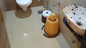 A small bathroom with a toilet, a shower, and a sink. - Hotel Lotus Villa (Ahmedabad)