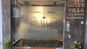 A hotel entrance with a glass door, "WELCOME" text, and a logo. - Hotel Lotus Villa (Ahmedabad)