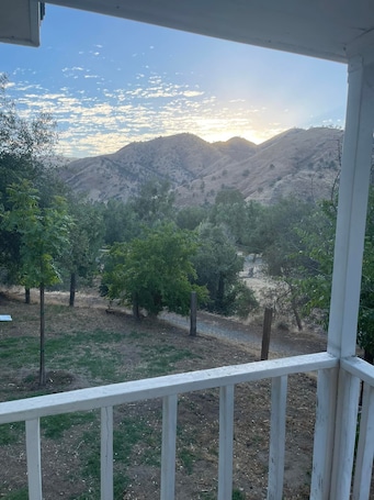 A view from a porch overlooking a valley with mountains in the distance.