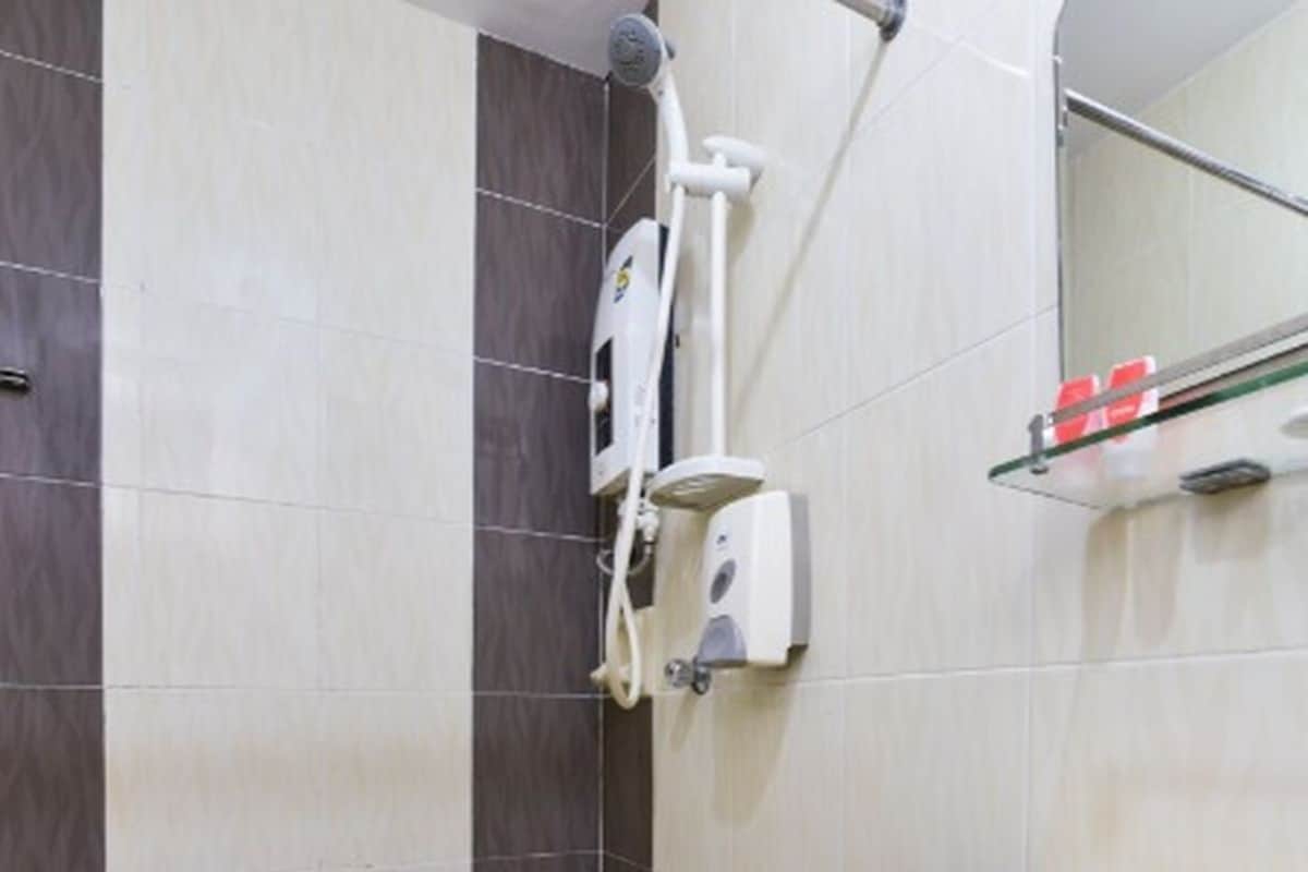 Un baño con ducha, lavamanos y espejo.