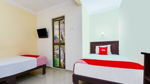 A hotel room with two single beds, a TV mounted on the wall, and a decorative door. - OYO 90562 J Hotel PJ (Petaling Jaya)