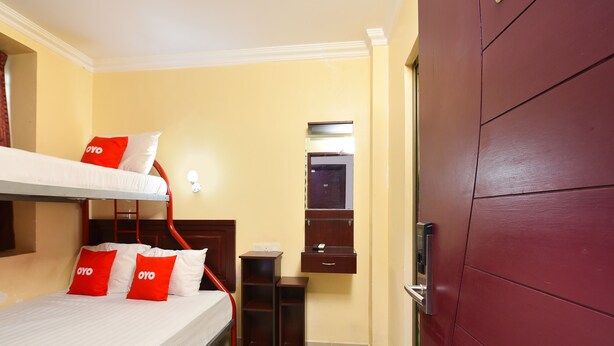A hotel room with a bunk bed, a small desk, a mirror, and a wardrobe. - OYO 90562 J Hotel PJ (Petaling Jaya)