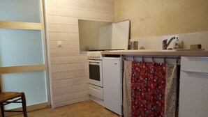 A compact kitchen with a stove, oven, and a small refrigerator. - Studio with breathtaking views, nearby hiking and swimming trails (Chirols)