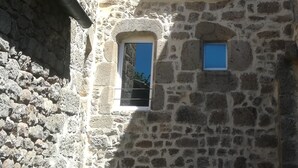 A stone building with multiple windows and a small balcony. - Studio with breathtaking views, nearby hiking and swimming trails (Chirols)