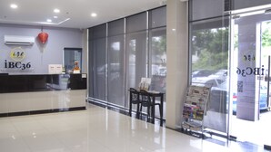 Una zona de recepción limpia y moderna, con mostrador, una silla y un atril para revistas.