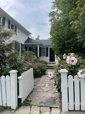 A house with a porch, a white picket fence, and a stone pathway leading to the front door. - Historic Downtown Hudson Home  (Hudson)