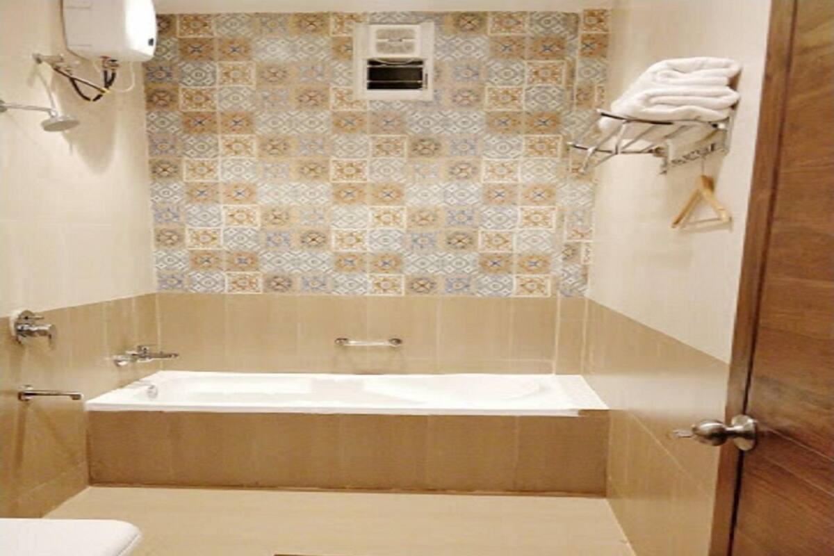 Un baño con bañera, inodoro y toallero.