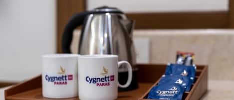 Two mugs with the Cygnett logo, a kettle, and a tray with Cygnett tea packets.