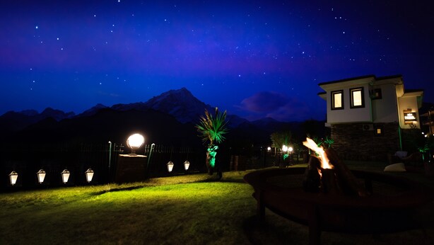 A nighttime view of a mountainous area with a house and a well-lit garden. - Mons Casa Boutique Hotel (Marmaris)