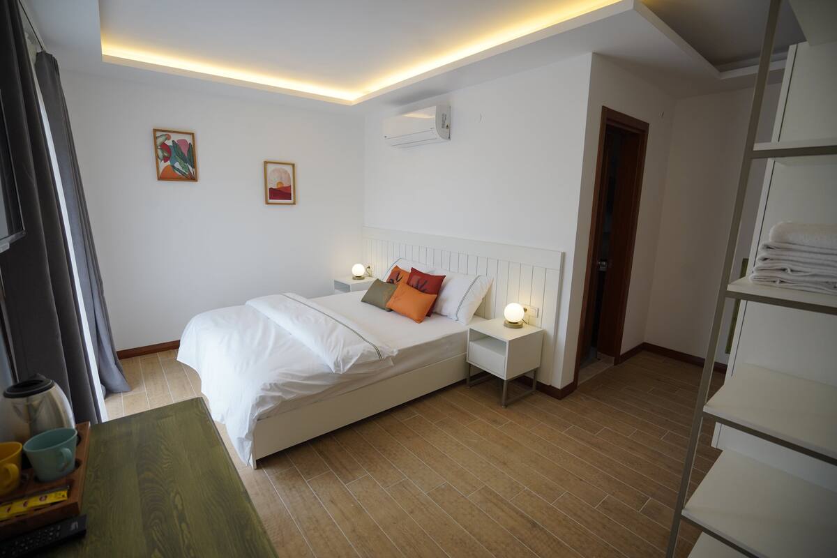 Une chambre à coucher moderne avec un lit, des tables de chevet et une petite table de nuit.