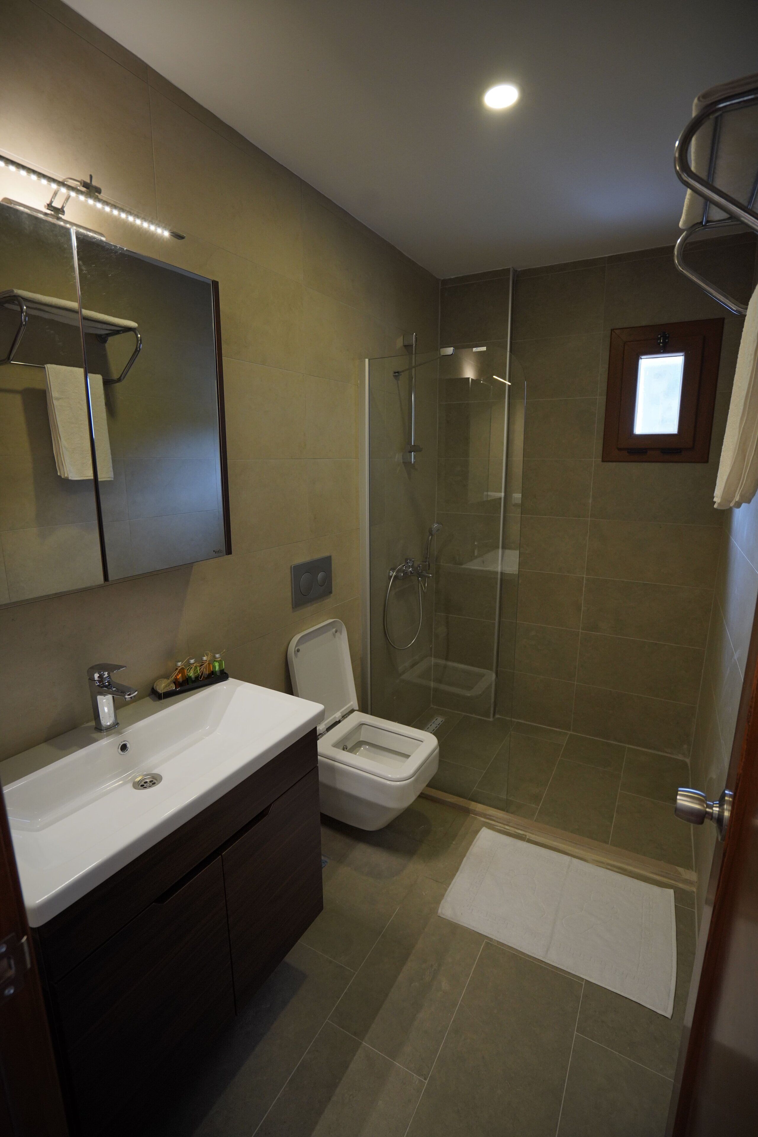Un baño moderno con ducha, inodoro y lavamanos.