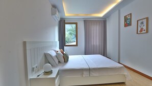 A bedroom with a bed, bedside table, and a window with curtains. - Mons Casa Boutique Hotel (Marmaris)