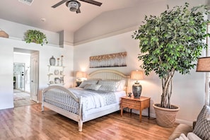 A bedroom with a bed, bedside tables, a potted plant, and a wall-mounted artwork. - Pool, Putting Green, Fire Pit: Elegant Peoria Home (Peoria)
