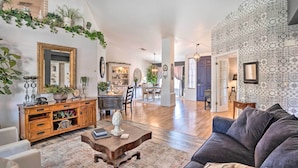 A spacious living room with a dark-colored sofa, a wooden coffee table, and a patterned rug. - Pool, Putting Green, Fire Pit: Elegant Peoria Home (Peoria)