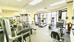 Un gimnasio con equipo de ejercicio diverso, que incluye cintas de correr y máquinas de pesas.