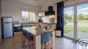 A modern kitchen with a dining area, a built-in oven, a microwave, and a coffee maker.