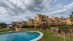 Un hôtel doté d’une piscine, de plusieurs balcons et d’une pelouse bien entretenue.
