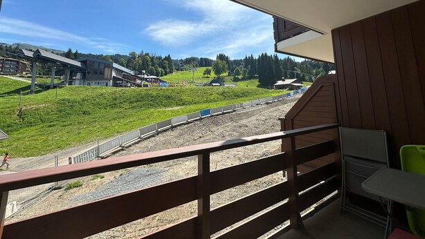 A balcony with a view of a train track and buildings in the background.