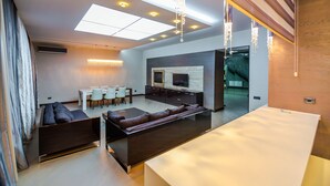 A modern living room with a sofa, dining table, and TV.
