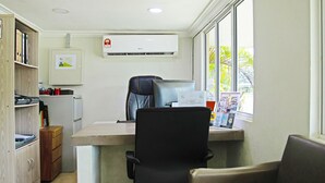 A small office with a desk, two chairs, a computer, and an air conditioner. - Capital O 90557 Dedsaan Beach Village (Kota Belud)