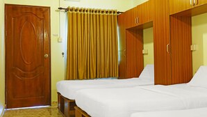 A room with two beds, a wooden wardrobe, a door, and a curtain. - Capital O 90557 Dedsaan Beach Village (Kota Belud)