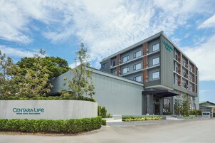 Un edificio de hotel de varios pisos con un letrero que dice 'Centara Life' y 'Wisma Hotel Ratchaburi'.