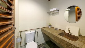 A bathroom with a toilet, sink, mirror, towel rack, and a small potted plant. - Collection O Ivory Hotel & Resort (Rawang)