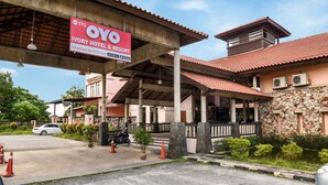 The OYO Ivory Hotel & Resort with a covered entrance, stone walls, and a tiled roof. - Collection O Ivory Hotel & Resort (Rawang)