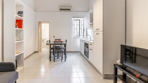 A modern kitchen with a dining area, a TV, and a built-in oven. - GuestHost - Functional apartment ideal for two people and equipped with the main services for a comfortable stay. The flat is located 7 minutes walk from the Central Station and 10 minutes from the Aldo Moro University and the Petruzzelli Theater, in an  (Bari)