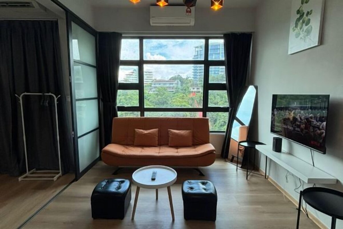 Una sala de estar moderna con un sofá, otomanas, una mesa de centro, un televisor y un ventanal con vistas a la ciudad.