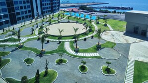 A landscaped courtyard with palm trees, a circular water feature, and a pool.