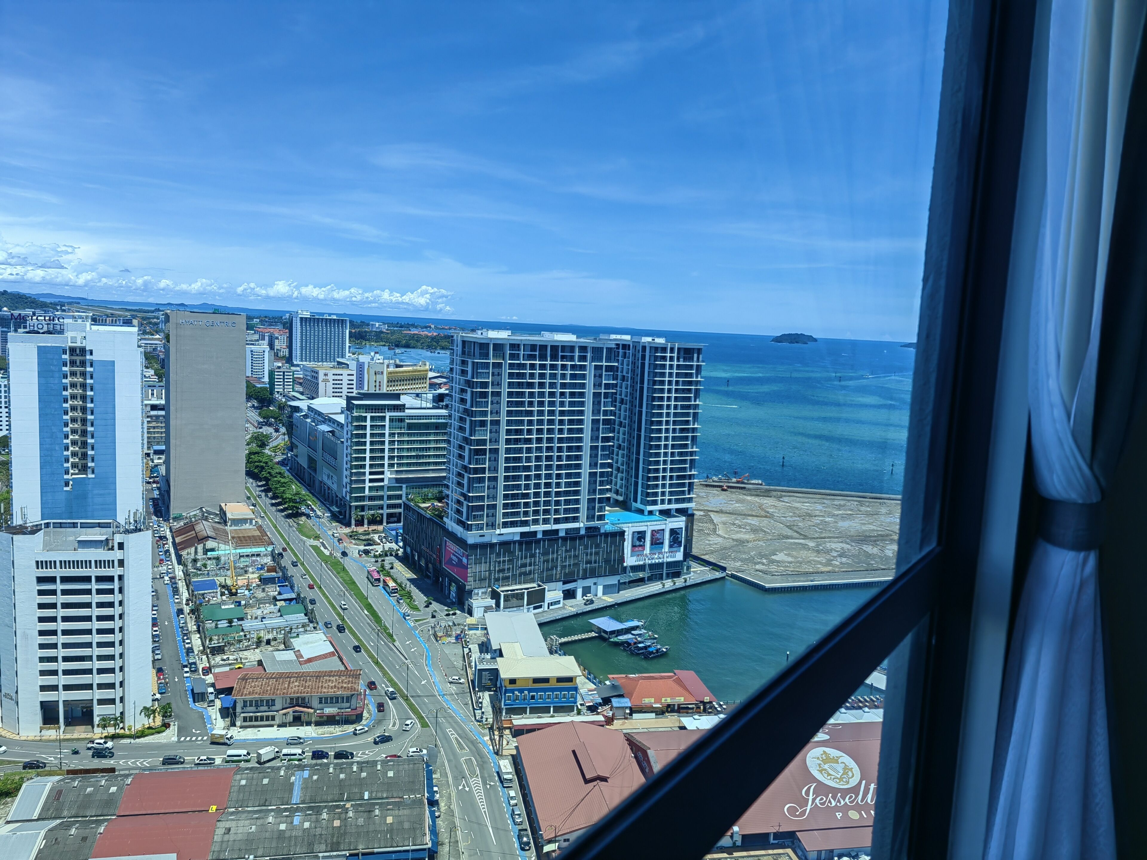 Un hôtel de grande hauteur offrant une vue sur le front de mer et un port de plaisance.