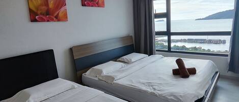 A hotel room with two beds, a large window with a view of a body of water and a pier, and an air conditioning unit on the wall.