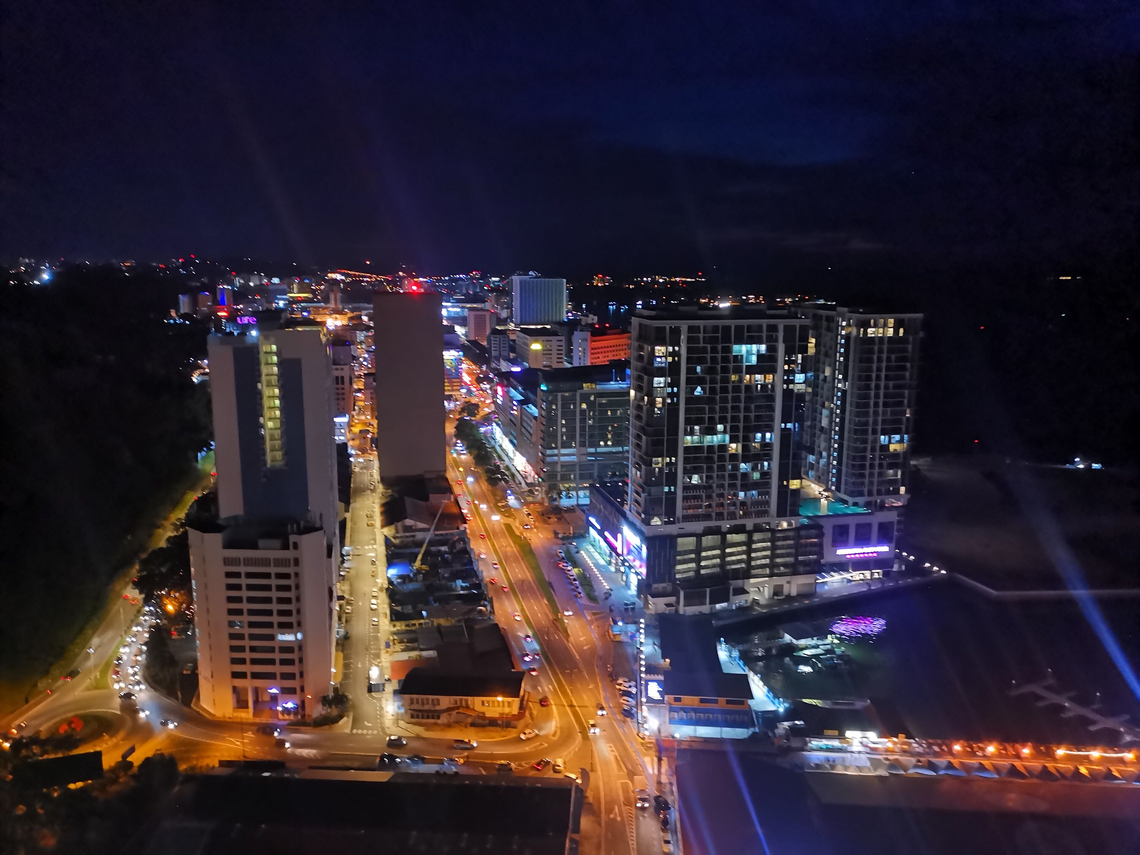 A nighttime cityscape with illuminated buildings and roads.