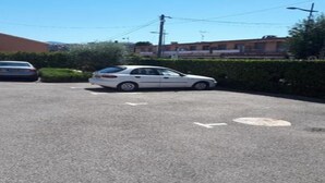 A parking lot with two cars, one white and one silver, and a building in the background. - Apartment for 4, air-conditioned 4, Terrace 15 m² - beach, town center on foot (Mandelieu-la-Napoule)