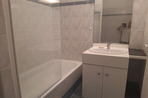 Ein Badezimmer mit Badewanne, Waschbecken und Spiegel.