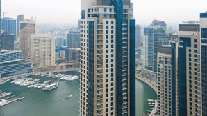 A high-rise building with a marina in the foreground.
