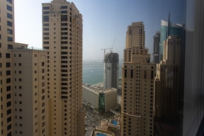 A high-rise building with multiple floors, a construction crane, and a view of the sea. - Spacious 2 bedroom with Amazing Marina View Rimal JBR (Dubai)