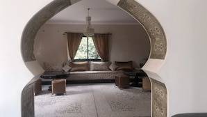 Una stanza accogliente con divano, lampadario e tappeto decorato.