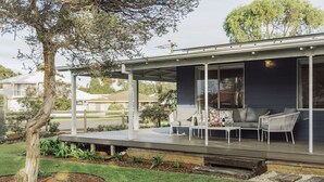 Een modern huis met een overdekte patio, compleet met buitenmeubilair en een groot raam.