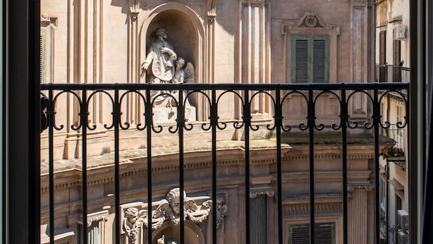 Un bâtiment historique doté d’un grand dôme, de sculptures richement décorées et d’une grille en fer forgé.