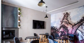 Un espacio de trabajo moderno con chimenea, varias zonas de estar y un gran mural con vistas a la ciudad.