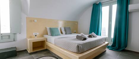A modern bedroom with a bed, bedside tables, and a window with curtains.