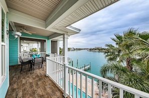 Enjoy serene views of the lake from this balcony with a table and chairs.