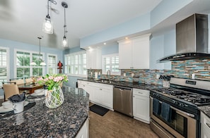 Enjoy cooking in this well-equipped kitchen with a large island, ample storage, and stainless steel appliances.