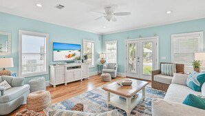 A spacious living room with a large flat-screen TV, comfortable seating, and a ceiling fan. - Private Pool ~ Screened Porch ~ Pet Friendly (Destin)