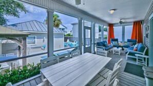 A covered outdoor patio with a table and chairs, a ceiling fan, and a view of neighboring houses. - Private Pool ~ Screened Porch ~ Pet Friendly (Destin)