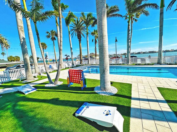 A poolside area with palm trees, a stop sign, and a view of the ocean.