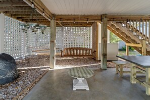 Un patio al aire libre con un banco de madera, una mesa y un cerramiento de celosía.